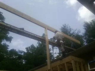 Carpenter setting a ridge beam over a new addition frame — Ice Dam Removal by Roofing Brothers in Mill Run