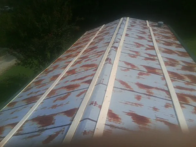 Rusted metal roof panels with new wood purlins before replacement — Storm Damage Roof Repair in Mill Run by Roofing Brothers