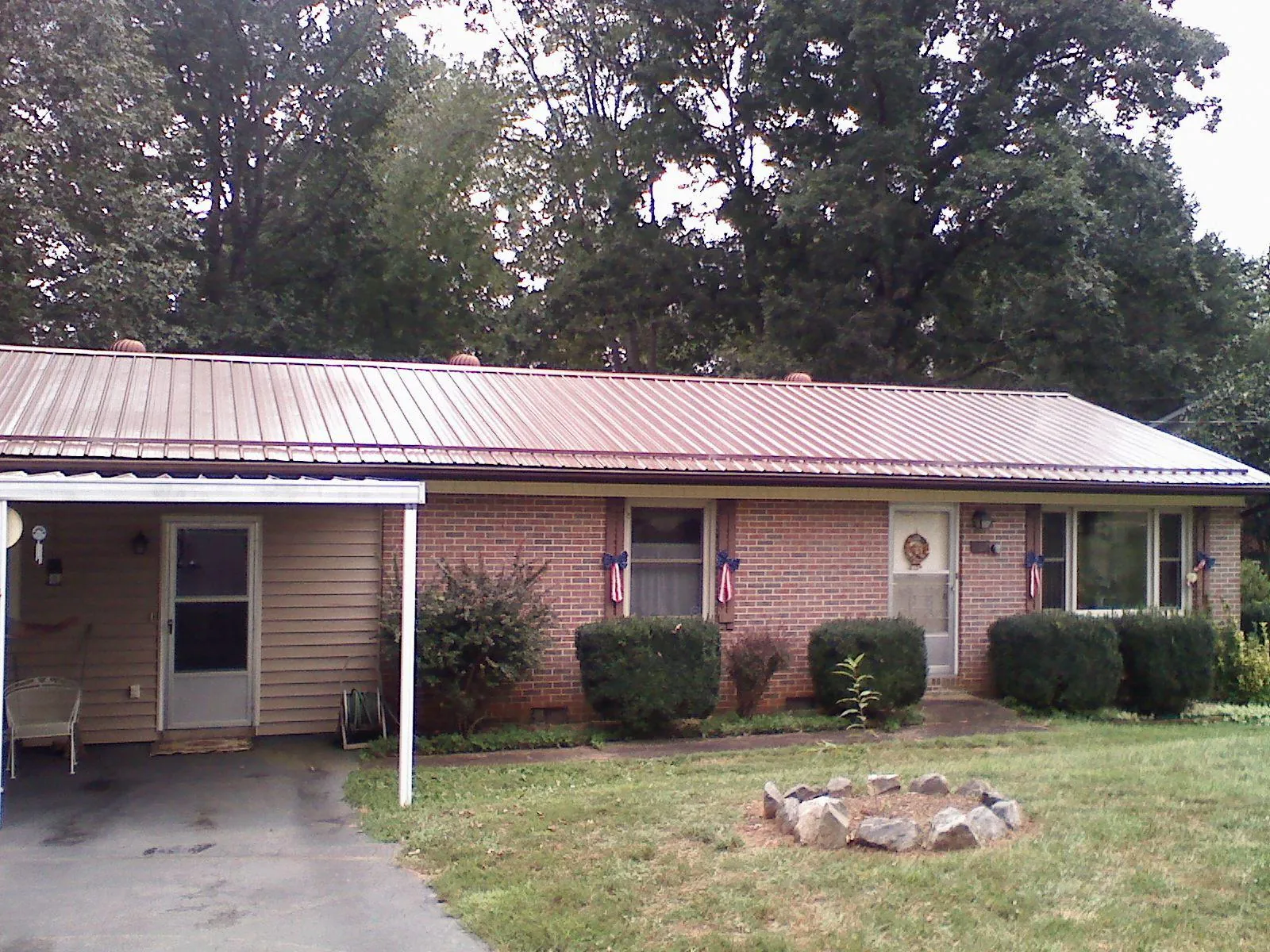 Bronze metal roof and carport on a brick ranch home — Roof Repair work by our crew in Mill Run